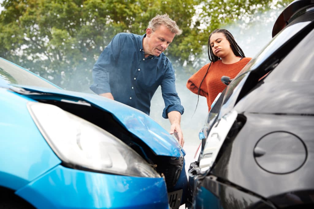 two motorists looking at the damage after a car accident