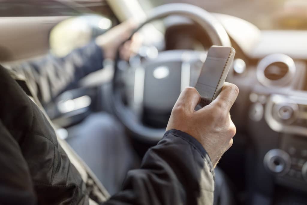 Using a phone in a car texting while driving concept for danger of text message and being distracted